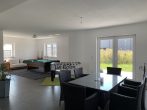 KNIPFER IMMOBILIEN - Erstbezug - Modernes Einfamilienhaus mit schönem Garten, Wallbox und PV-Anlage! - Wohnzimmer